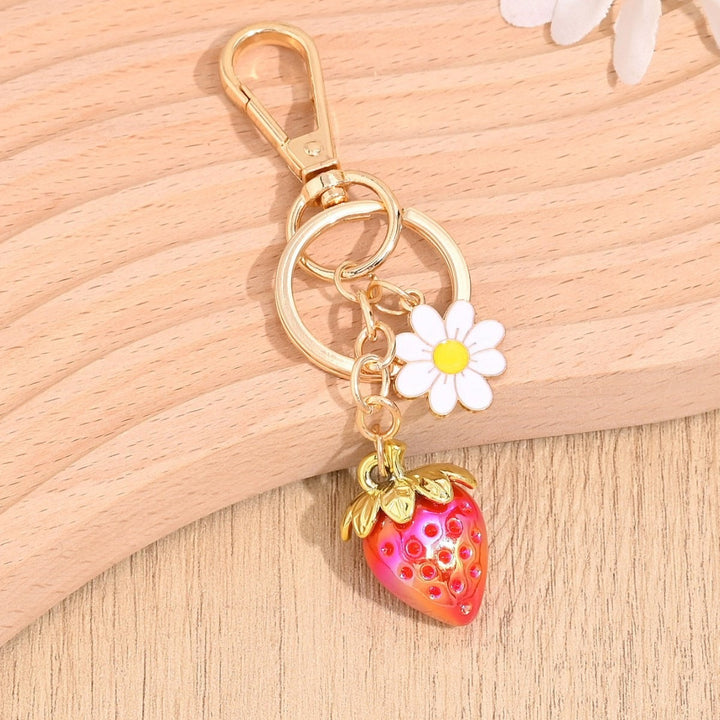 Pink sparkling strawberry keychain accessory, vibrant and fun.