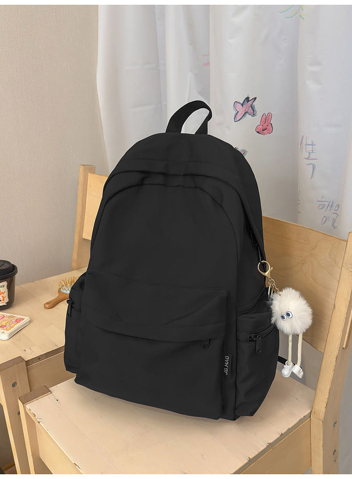 Versatile minimalist black nylon backpack for school. Unisex, multi-functional, ideal for daily commute & travel.