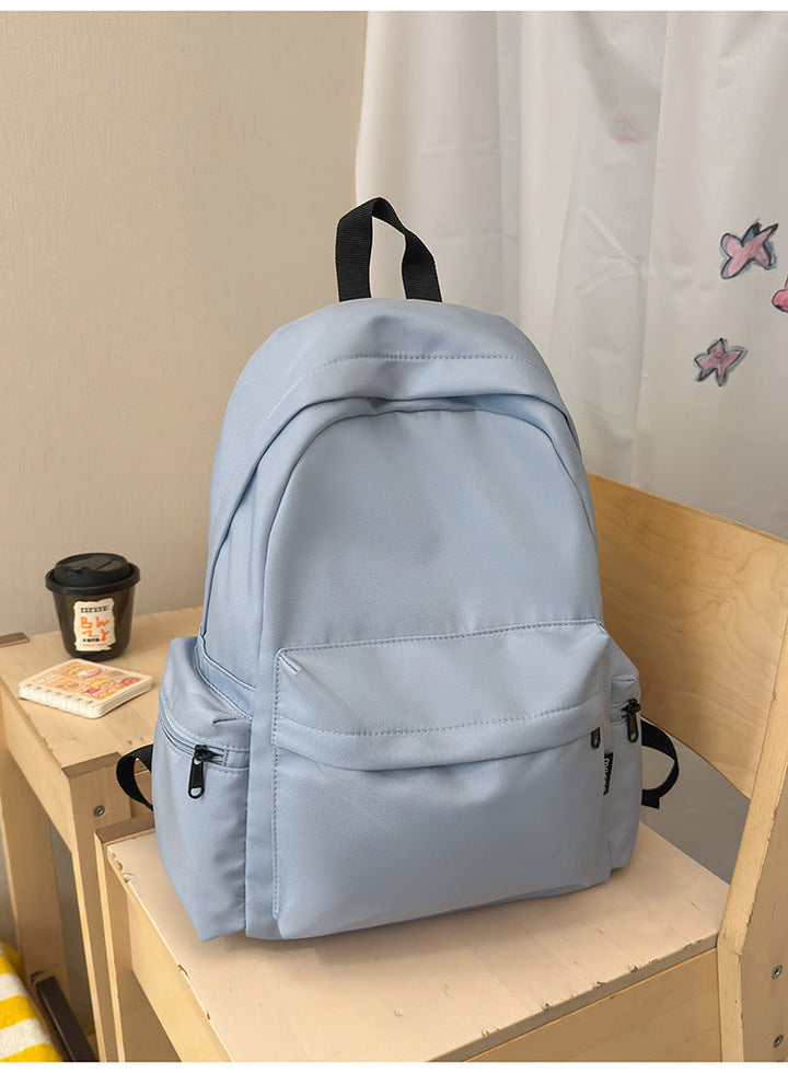 Sleek black minimalist backpack. Unisex, durable nylon, multi-functional for school, travel, & daily use.