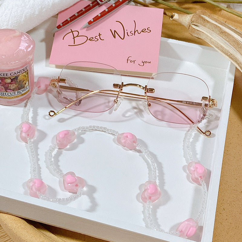 Stylish glasses strap with delicate pink heart charms. Secure eyewear chain, women's fashion accessory.