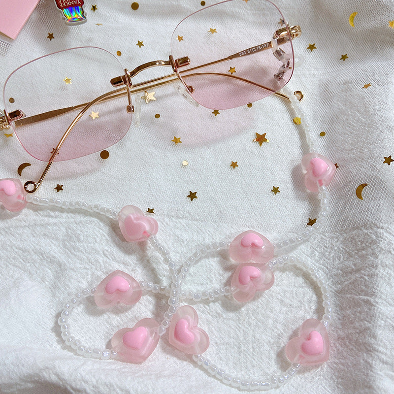 Fashionable glasses strap with pink heart charms, keeping eyewear secure & stylish. Perfect women's accessory.