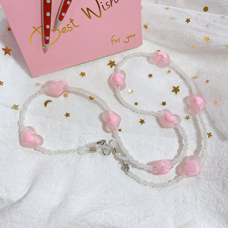 Chic glasses strap featuring multiple pink heart charms. A practical yet stylish fashion accessory for women.