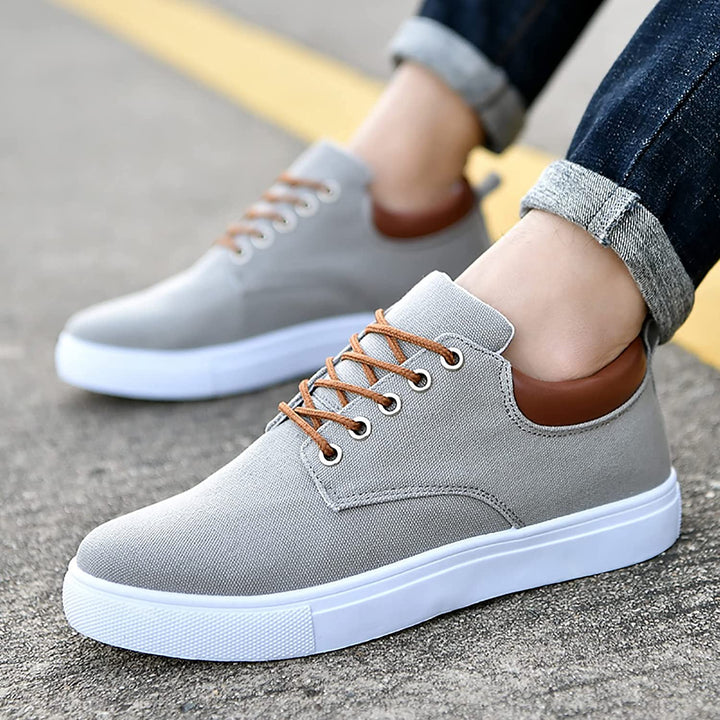 Close-up of the lace-up detail on men's stylish low-top casual sneakers, black/white.