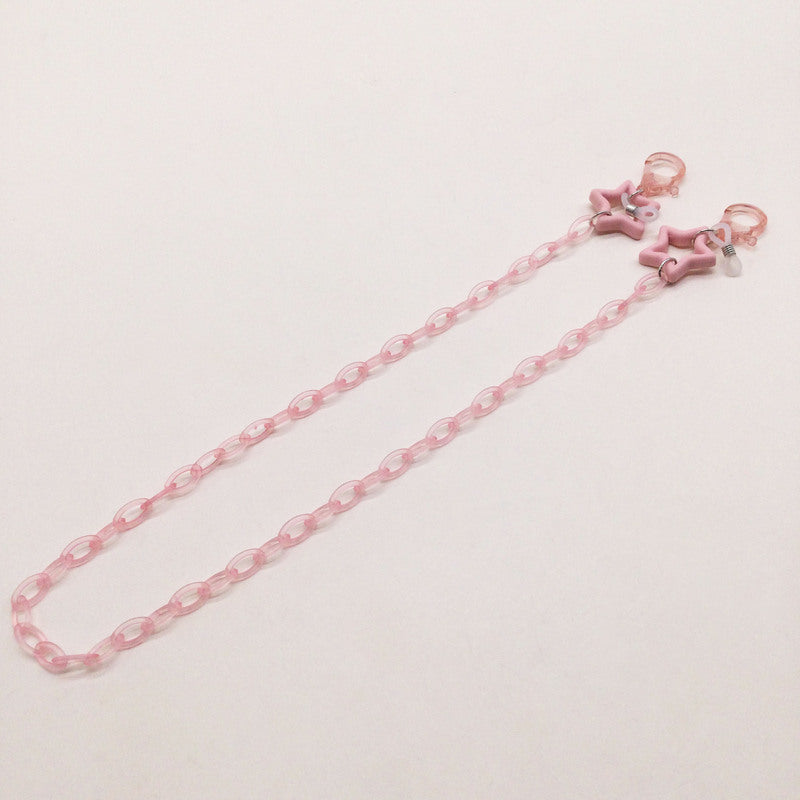 Close-up of a decorative star charm on a stylish women's eyeglass holder chain. Fashionable detail.