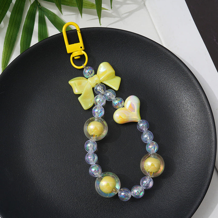 Close-up of a colorful beaded keychain featuring various charms, a trendy purse accessory and fashion statement.