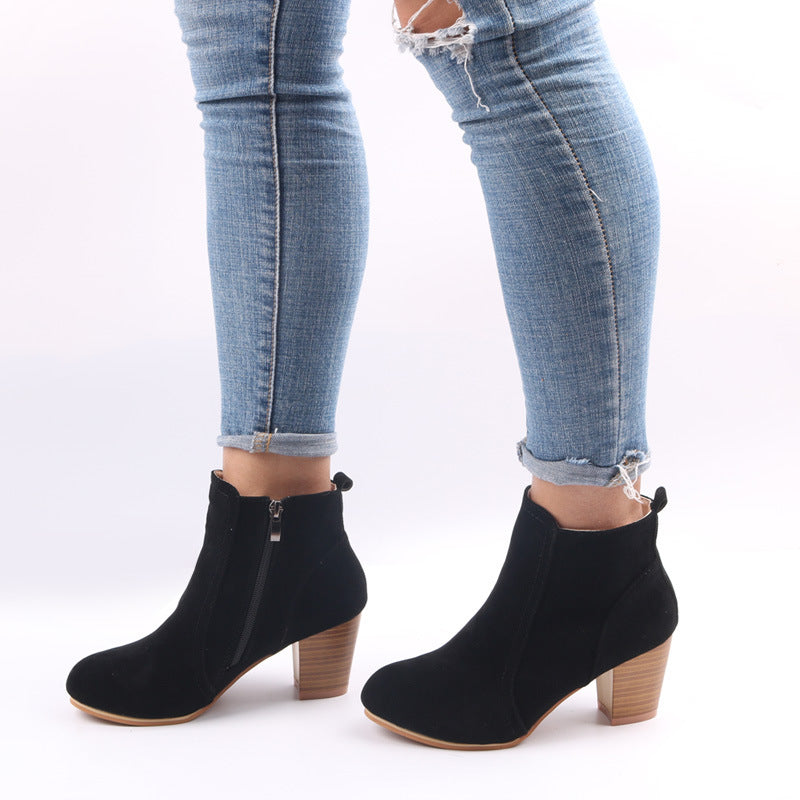 Close-up of chic women's ankle boot showcasing the chunky heel, elegant round toe, and functional side zip detail.