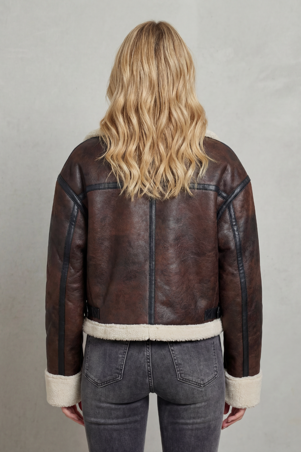 Detailed shot of women's brown cropped aviator jacket, highlighting the luxe collar & chic design for cold weather.