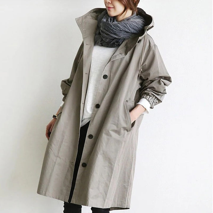 Stylish women's hooded A-line long rain jacket, perfect for all-weather protection & lightweight spring/fall outerwear.
