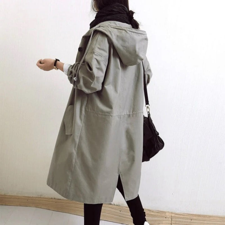 Detailed view of the women's stylish A-line long hooded rain jacket, highlighting waterproof fabric & modern design.