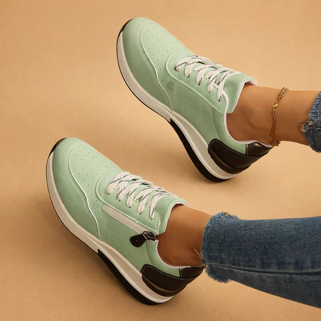 Detail shot: Perforated design on women's low-top sneakers, highlighting cushioned sole for all-day comfort.