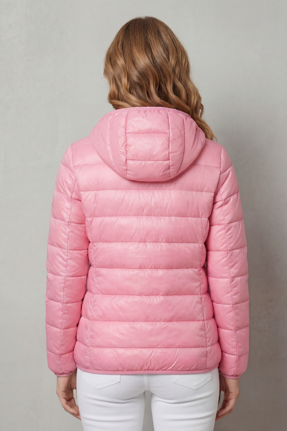 Packable women's waterproof coat, ideal for travel & versatile all-weather layering.