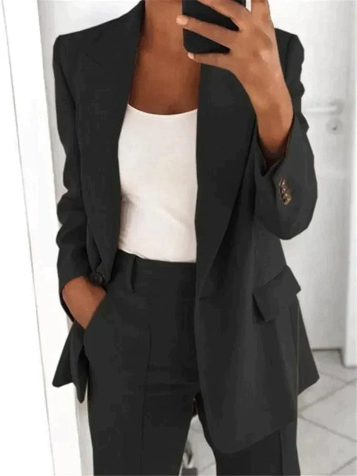 Elegant women's two-piece suit with a relaxed fit blazer and trousers, ideal for comfortable professional attire.
