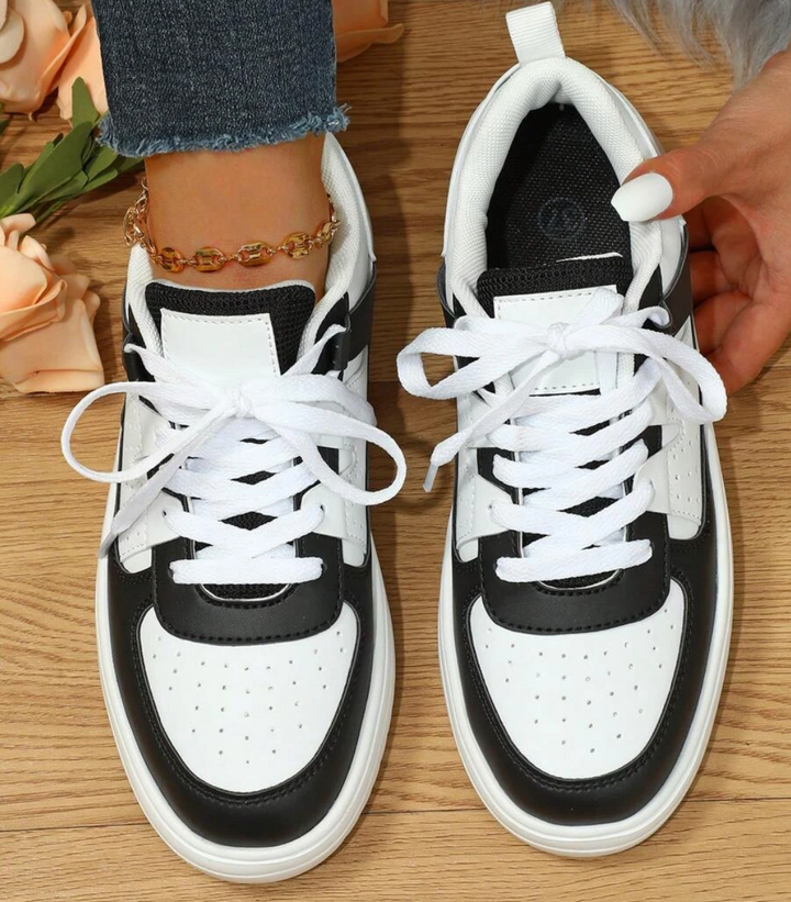 Elegant women's white sneakers, offering sporty comfort and a versatile look for daily fashion.