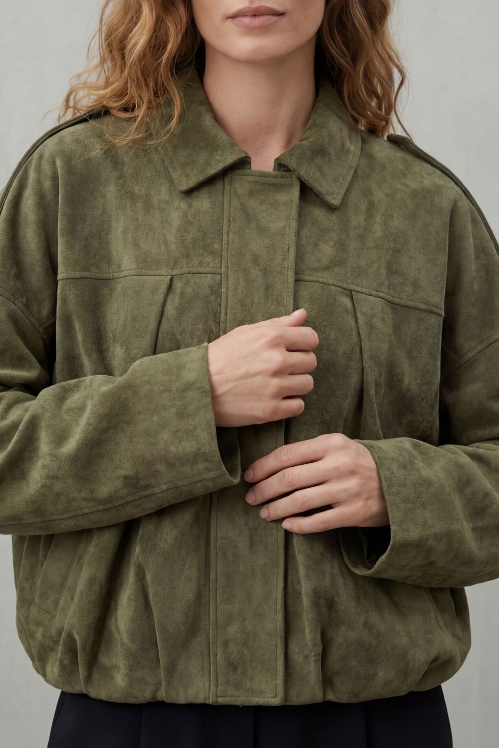 Close-up of a women's stylish volume bomber jacket, highlighting the ribbed cuffs and hem details.
