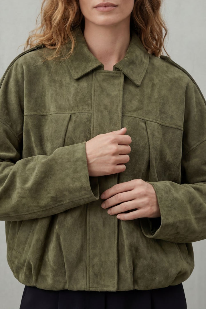 Close-up of a women's stylish volume bomber jacket, highlighting the ribbed cuffs and hem details.