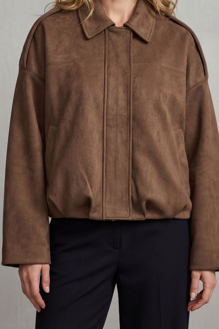 Back view of a women's structured volume bomber jacket, demonstrating its elegant, oversized silhouette.