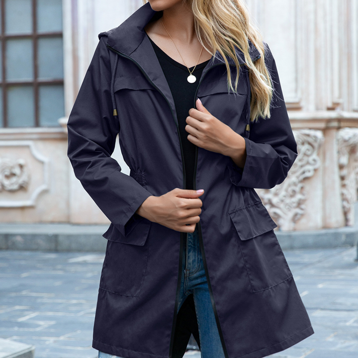 Versatile women's waterproof long coat, a hooded rain jacket designed for comfort and protection in bad weather.