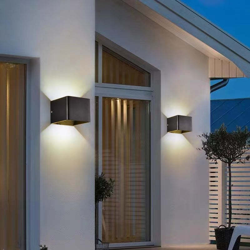 Tavey contemporary LED wall light, black, enhancing the facade of a modern home.