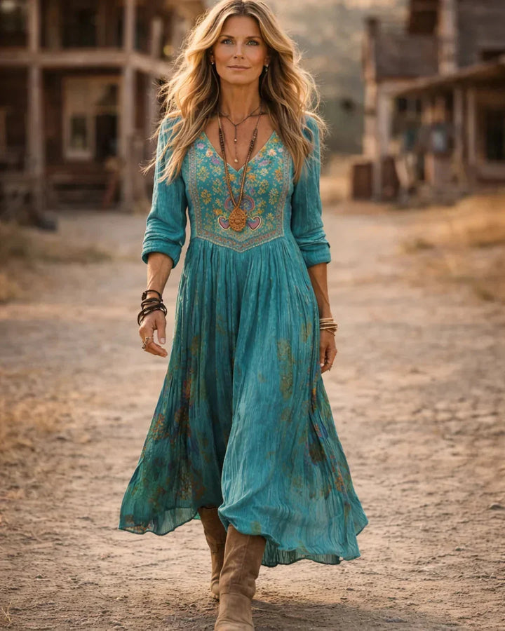 Elegant women's bohemian maxi dress, teal with intricate embroidery, V-neck & long flowy sleeves.