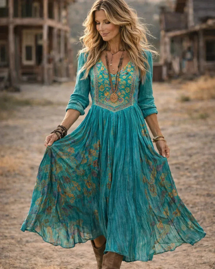 Close-up: Intricate embroidery on a teal V-neck bohemian maxi dress for women, long sleeves. Elegant summer style.