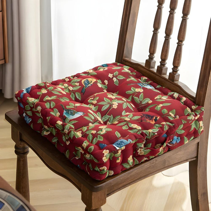 Comfortable polyester chair cushion for indoor & outdoor seating, with ties & a vibrant bird leaf design.