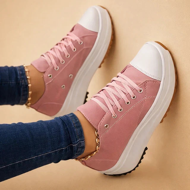 Close-up of a white women's high-top sneaker showing laces and trendy chunky sole details.