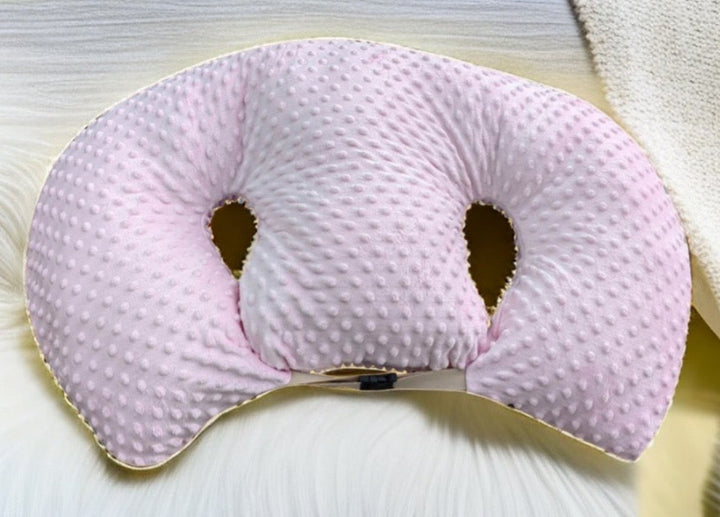 Newborn twins comfortably resting on a supportive tandem feeding pillow.