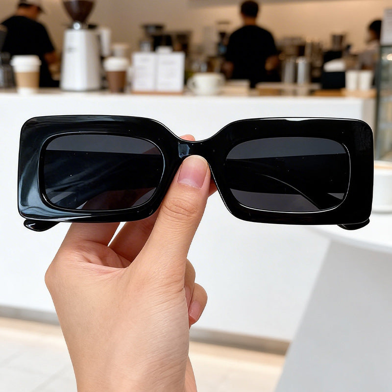Close-up: Unisex bold retro square sunglasses. Features durable frame, modern design, and UV protective lenses.