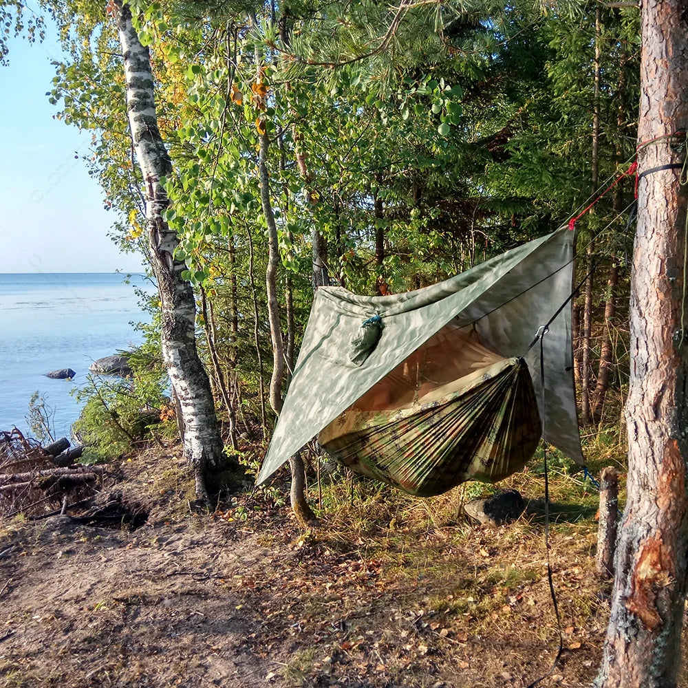 Complete camping gear: durable hammock, fine mesh mosquito net, and large waterproof rain tarp for any weather.