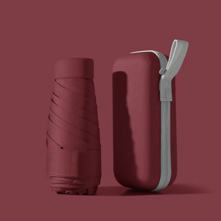 Unisex folding umbrella, closed and securely stored in its waterproof case, perfect for bags.