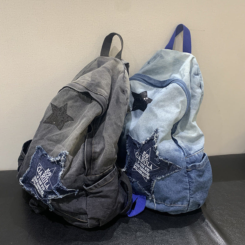 Durable unisex student denim backpack with star appliqué, multi-pockets, and padded straps for school or travel.