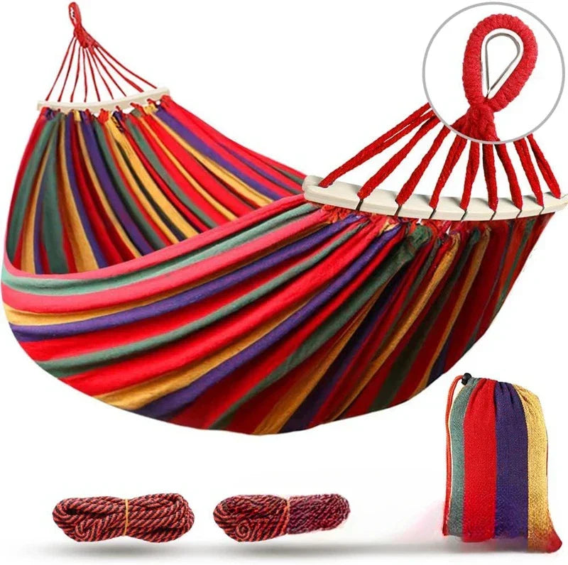 Relaxing double canvas hammock with wooden spreaders, great for outdoor lounging, garden, patio, or camping trips.