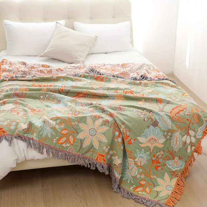 Decorative floral boho throw blanket with intricate patterns & fringe, made from a soft cotton blend for rustic style.
