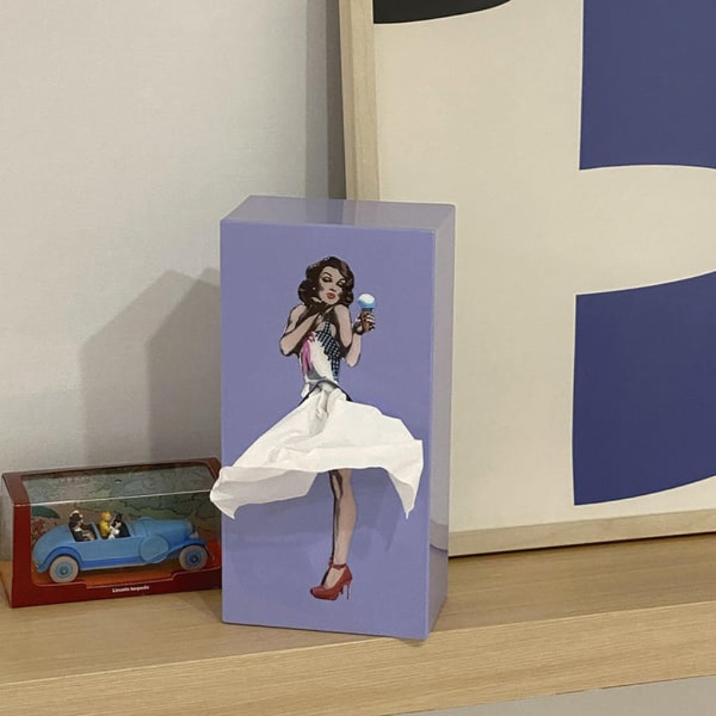Statement decorative tissue box with a 'flying skirt' design. Elevates tabletop decor in any unisex home.