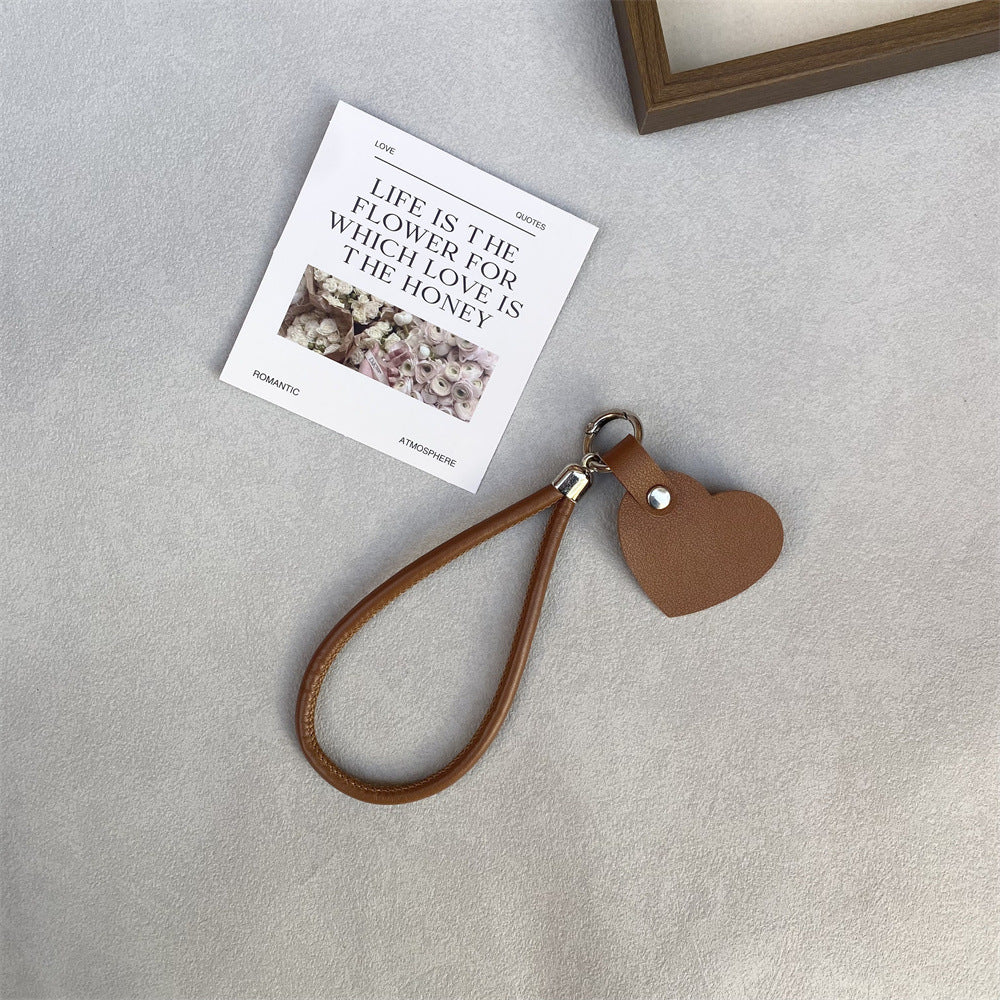 Double-duty leather heart keychain & bag charm, a durable & stylish gift idea.