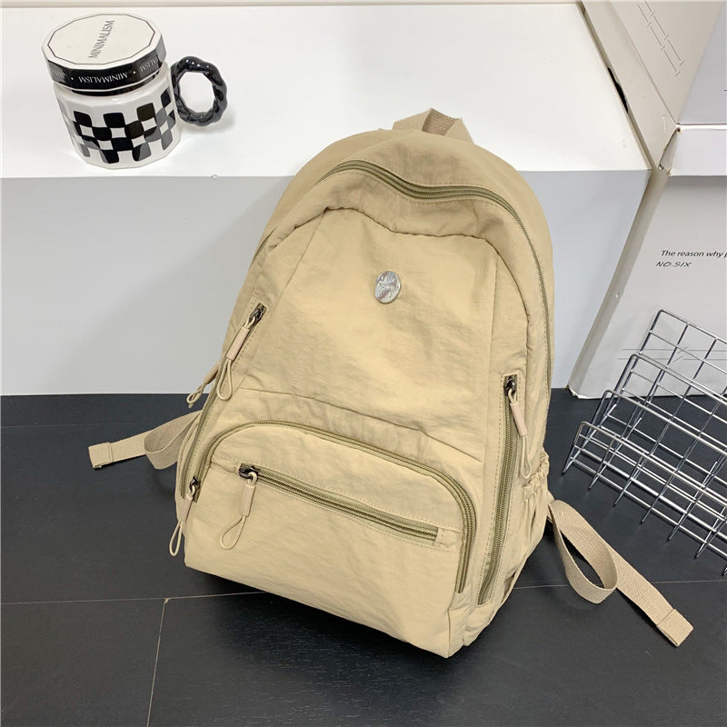 Stylish grey unisex lightweight travel backpack, a versatile multi-functional daypack for school, work, or outdoor use.