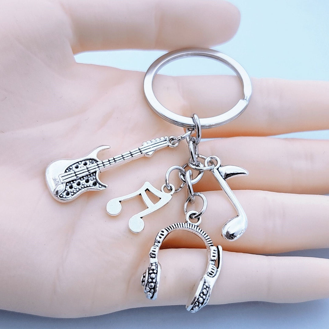 Metal guitar, headphone, and music note keychain charm. A perfect unisex accessory for any music enthusiast.