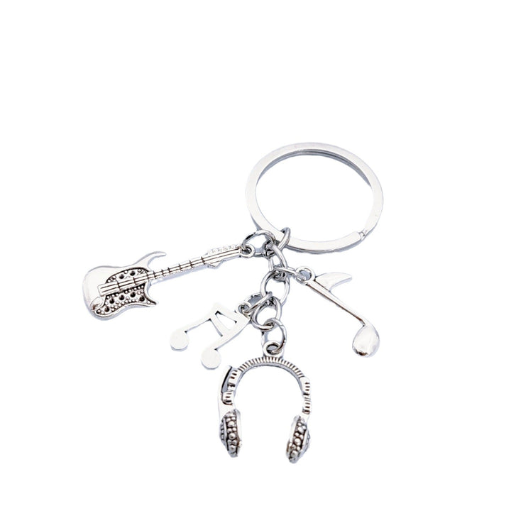 Assorted musical instrument charms on a metal keychain. Guitar, headphones, & music notes for music enthusiasts.