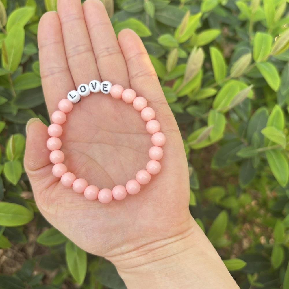 Simple pastel bead bracelet with 'LOVE' letters. Dainty and elegant unisex friendship accessory.