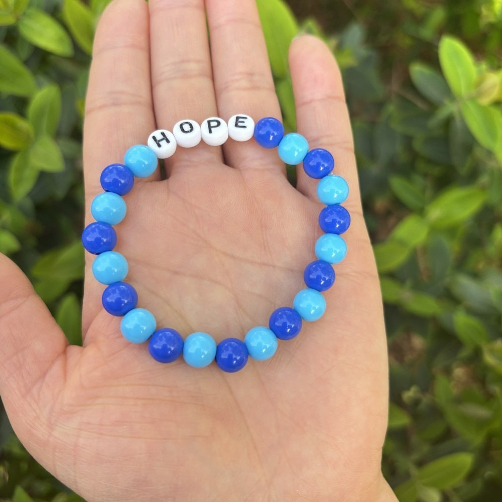 Versatile unisex accessory: Pastel bead friendship bracelet with 'LOVE' lettering. Easy stretch fit.