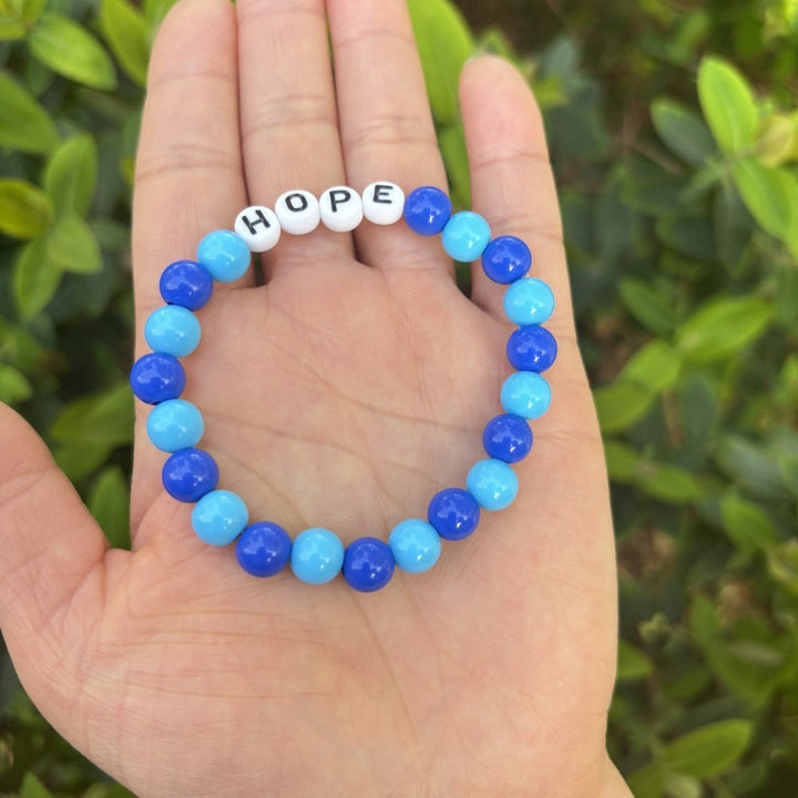 Versatile unisex accessory: Pastel bead friendship bracelet with 'LOVE' lettering. Easy stretch fit.