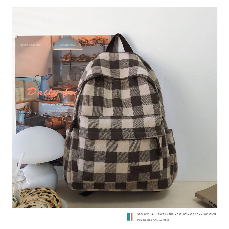 Unisex plaid patterned casual backpack with front pocket, perfect for school, travel, or everyday use.