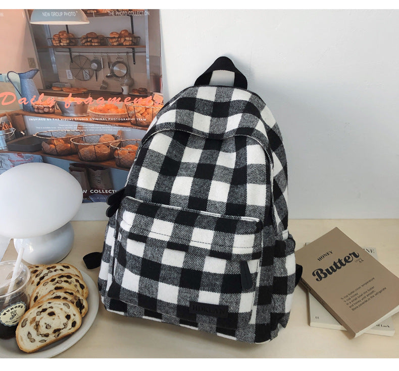 Spacious unisex plaid school backpack with adjustable straps, ideal for students, travel, and daily essentials.