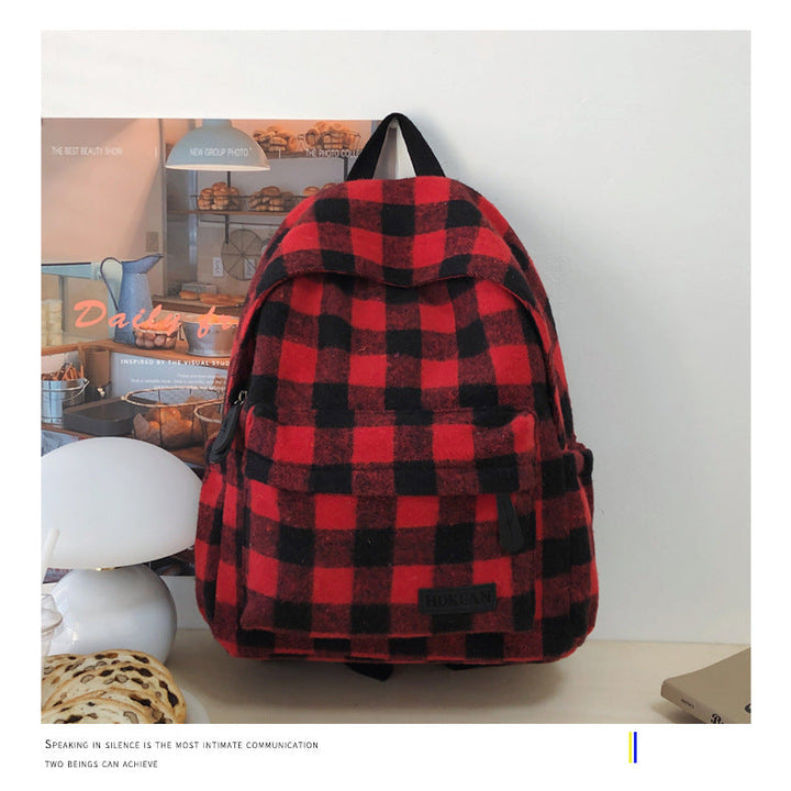 Durable unisex plaid travel backpack with padded, adjustable shoulder straps and top handle for comfortable carrying.