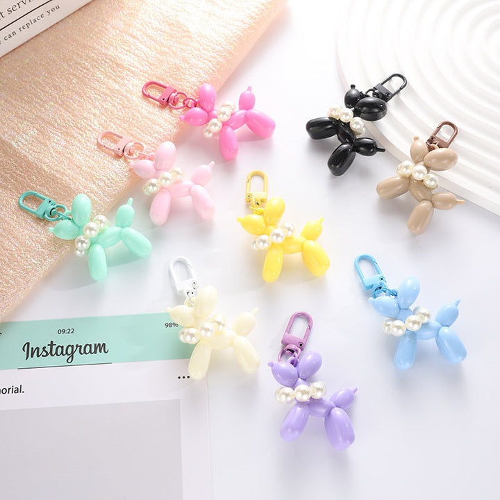 Unisex playful balloon dog keychain with elegant bead charm, a stylish bag accessory.