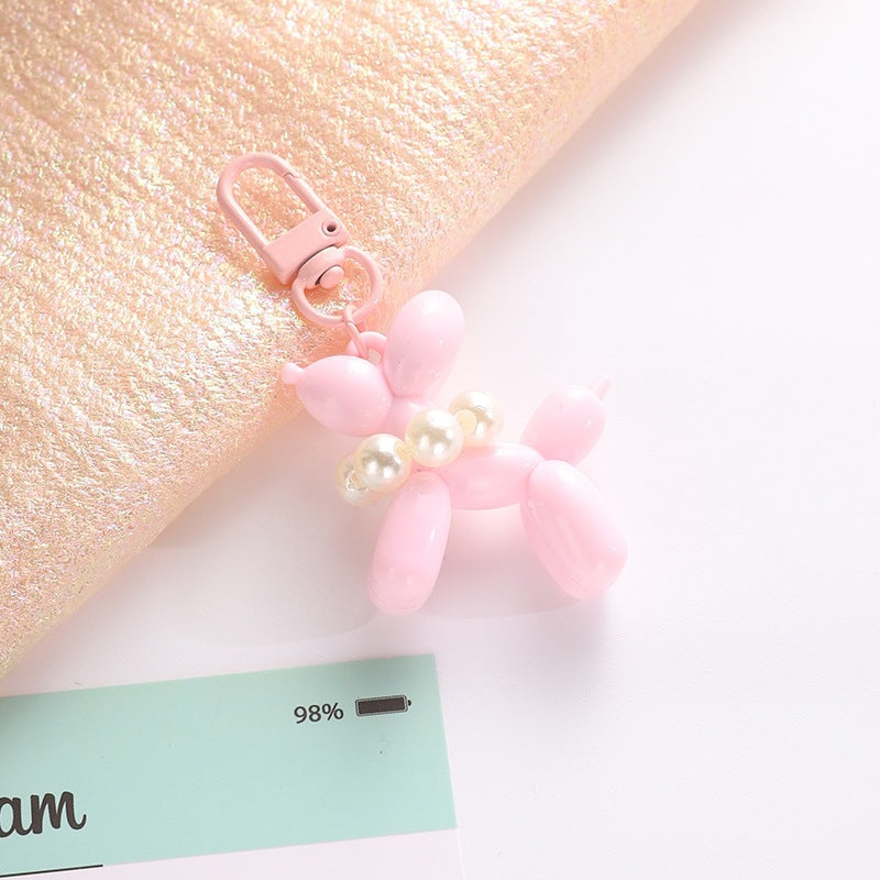 Chic balloon dog keychain with elegant bead, a fun and versatile fashion accessory.