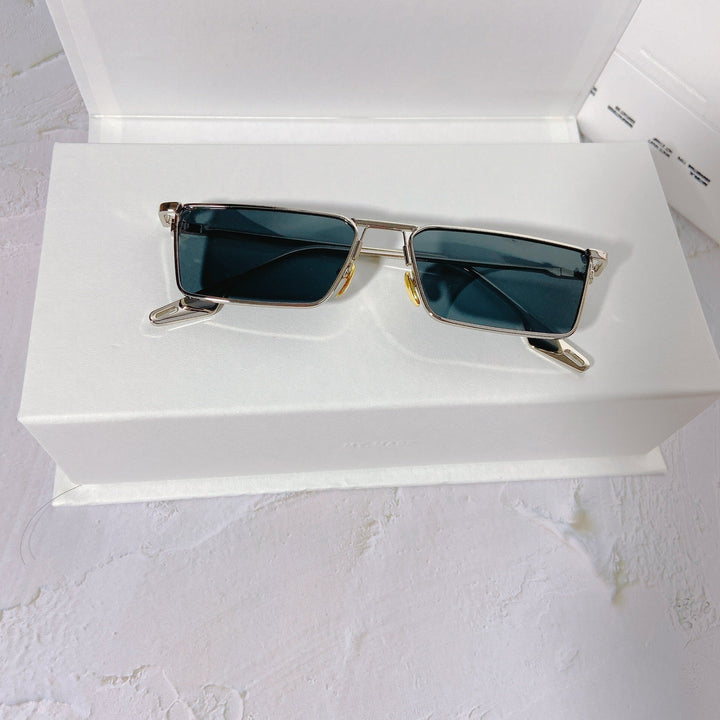 Closeup: Unisex rectangular metal frame sunglasses with dark UV400 protective lenses.