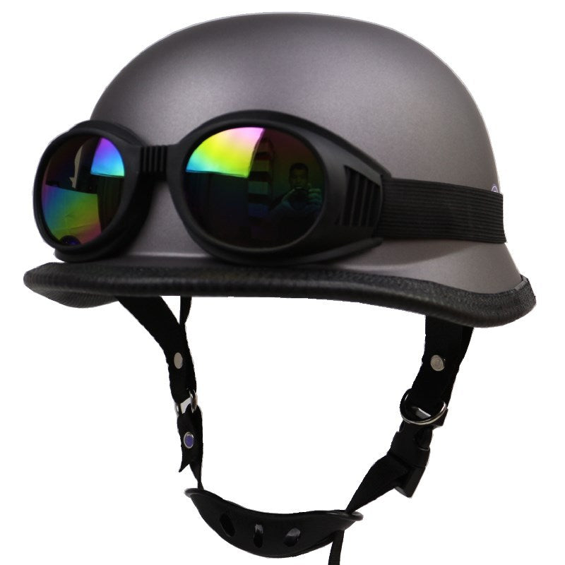 Classic black retro half-helmet motorcycle with goggles on a display head, showcasing rider style.