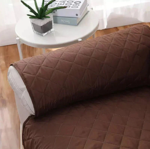 Soft grey quilted recliner cover, perfect furniture protector for a cozy living room.