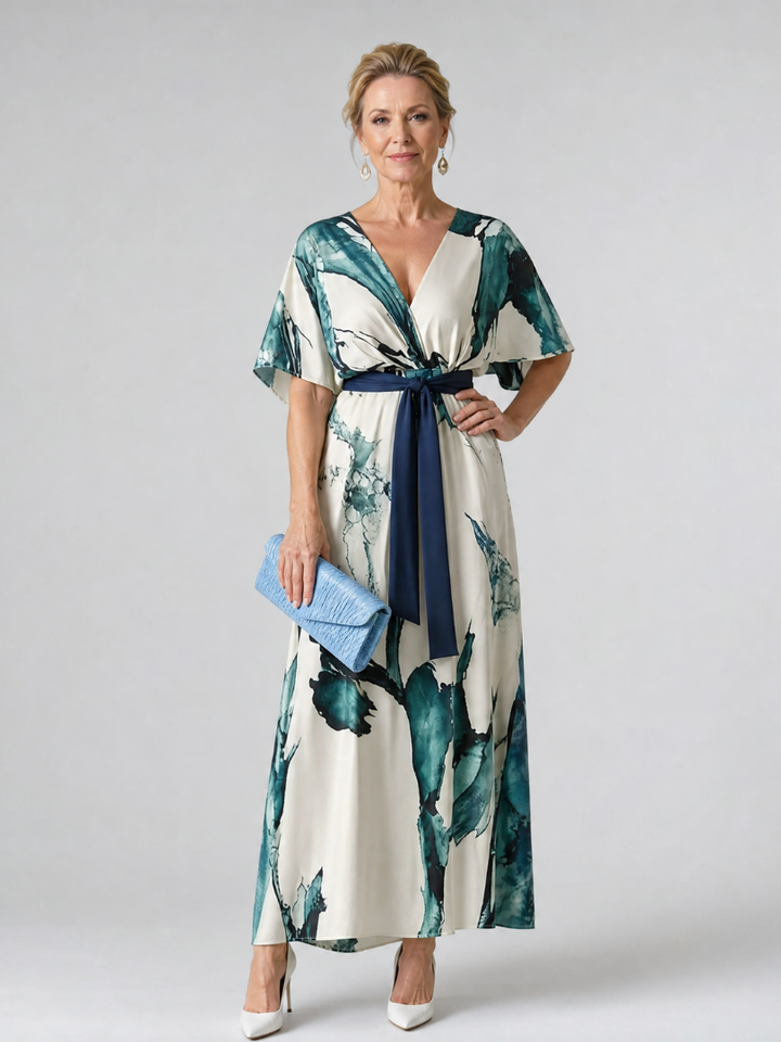 Vibrant women's abstract print maxi dress with flutter sleeves, V-neck, and tie waist for a relaxed, elegant summer look.